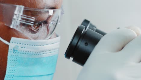 Científico mirando a través de un microscopio