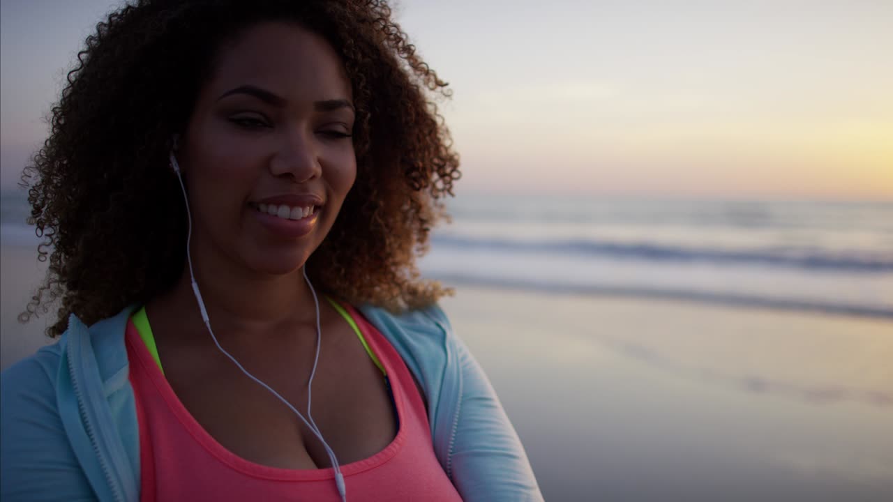 Mulher de etnia dançando ao som de música no smartphone