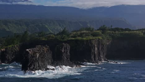 Amplia-Panorámica-Aérea-De-Olas-Bañando-Acantilados-En-La-Costa-Norte-De-Maui,-Hawaii.