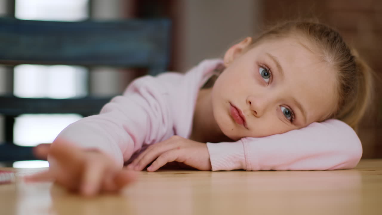 Sad Child Leaning on Table
