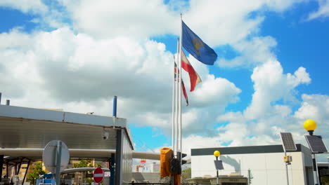 flags of gibraltar, the united kingdom, and the european union waving in the wind against a bright blue sky