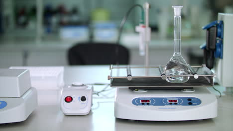 Laboratory equipment in modern lab. Pure liquid mixing in glass flask
