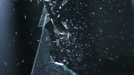 shattering glass fragments on a dark background