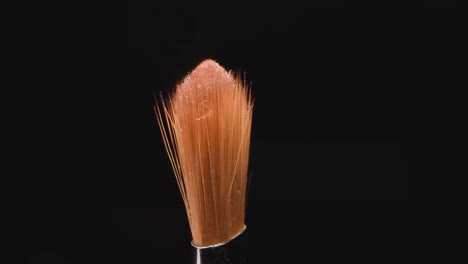 old brush with glitter on orange bristles for eye makeup