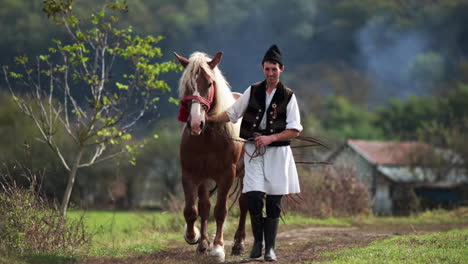 rumano en traje tradicional camina junto al caballo 3