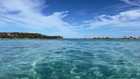 Low-angle-sea-water-surface-point-of-view-of-Santa-Giulia-beautiful-beach-in-Corsica-island,-France