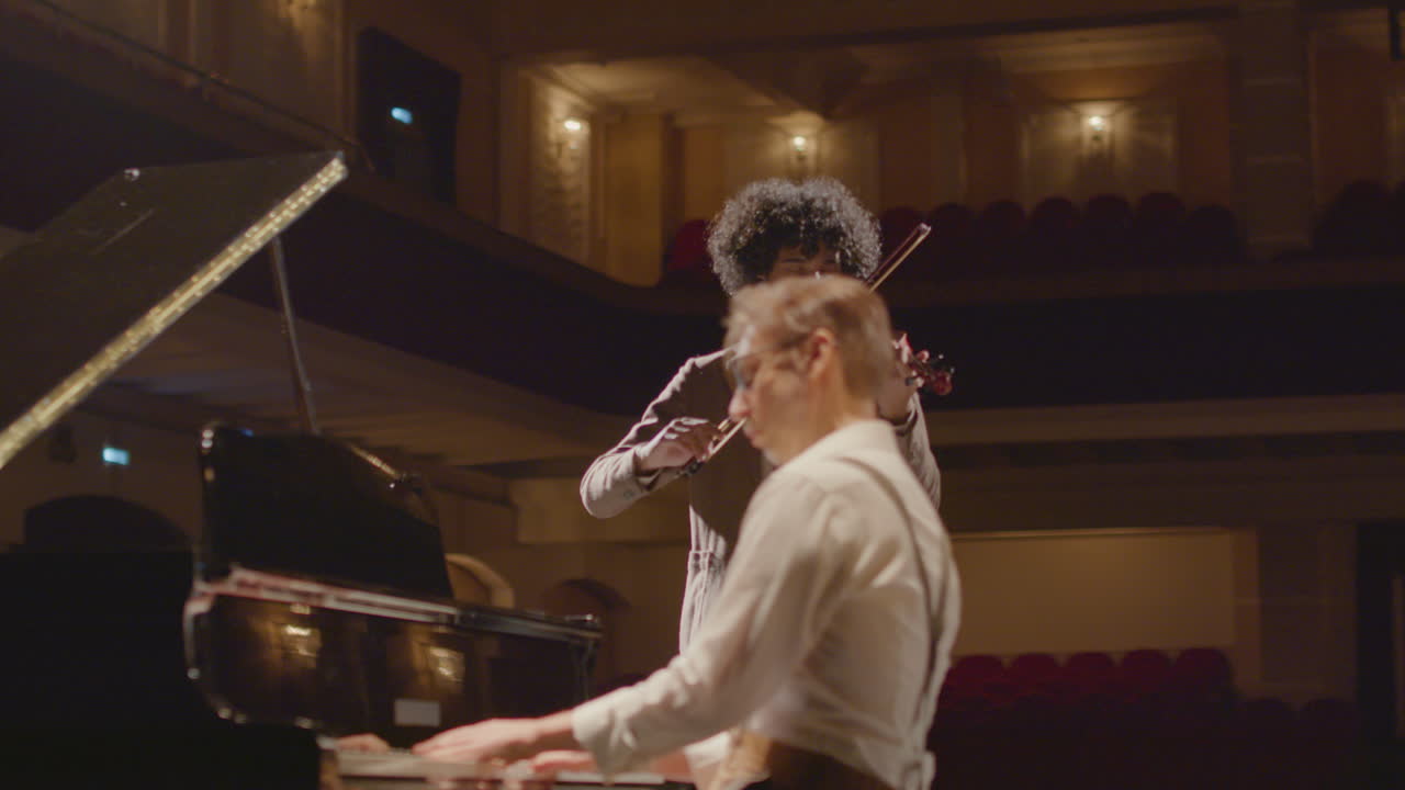 Piano and Violin Duo Performing Classical Music on Stage