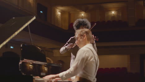 piano and violin duo performing classical music on stage