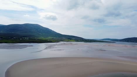 Drone-footage-of-Achill-Sound-at-evening-Low-Tide-beside-Michael-Davitt-Bridge,-towards-Atlantic-Ocean