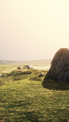 serene sunset landscape with rocks and grassy field