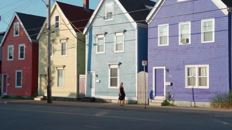 halifax colourful homes with woman walking in front of in the morning