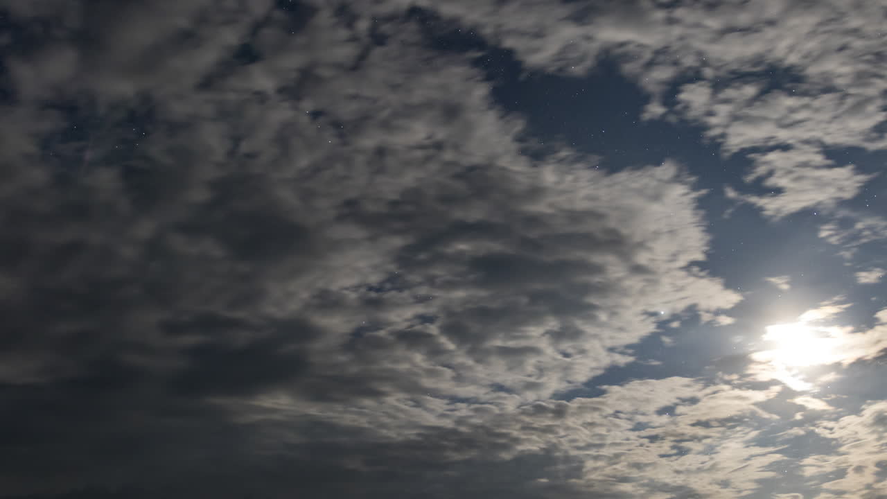 timelapse del cielo nocturno con la luna, las estrellas y las nubes en movimiento