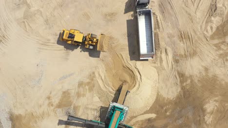 Aerial-view-loading-bulldozer-in-open-air-quarry