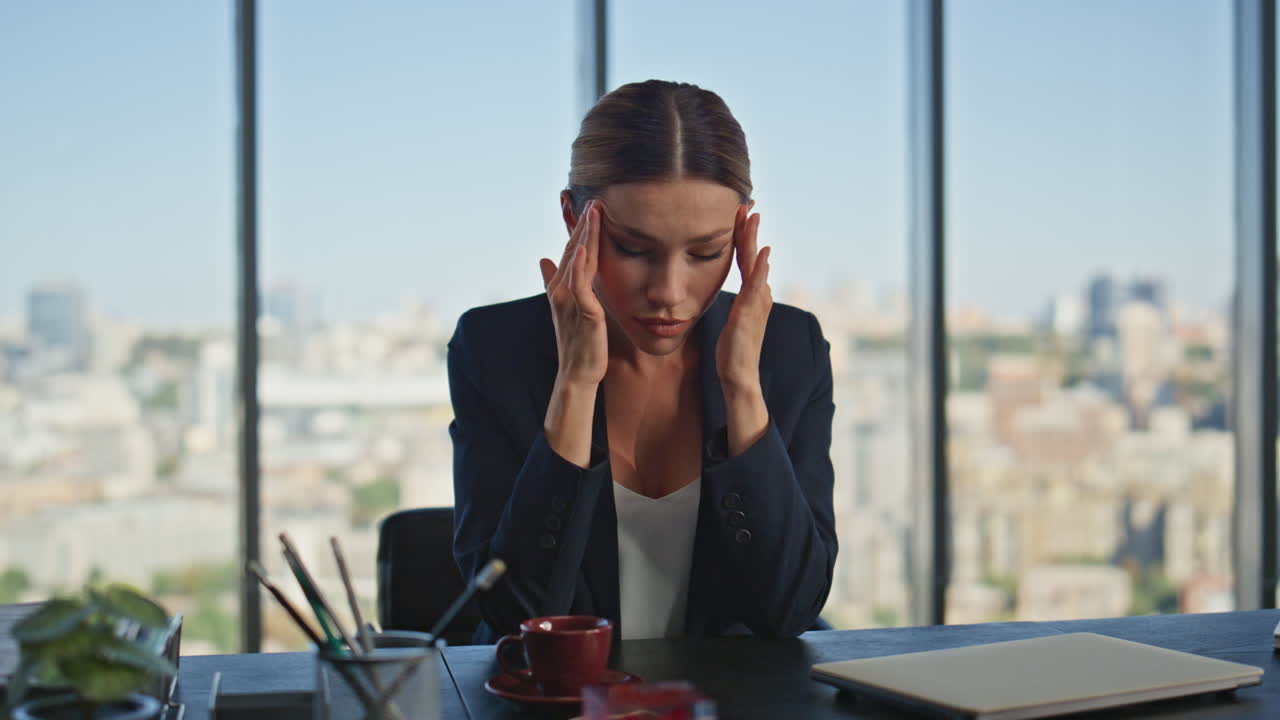 Dipendente stressato che si massaggia la testa alla scrivania. Dirigente stanco che soffre di mal di testa.