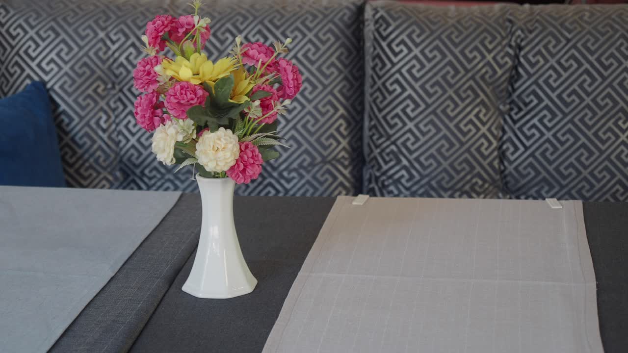 Colorful Artificial Flowers in a White Vase on a Table