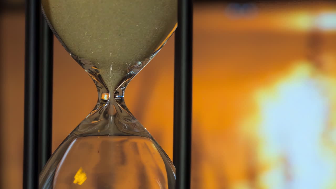 клюз песочных часов с песком, проходящим через него, измеряет прохождение времени, поскольку гравитация тянет гранулы из одной камеры в другую