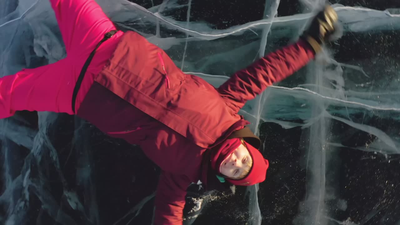 소녀는 공중에서 키스하고 얼음 위에 누워있고, 드론은 그녀로부터 멀어지고, 나선형으로 회전합니다.