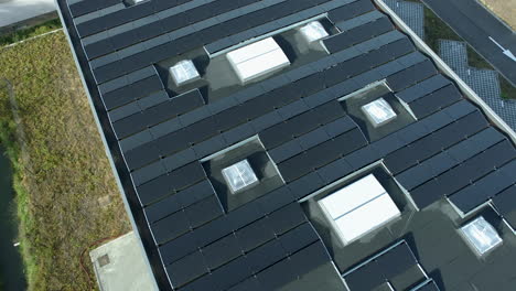 Solar-Panels-on-Industrial-Roof.-Aerial,-Sunny-Day