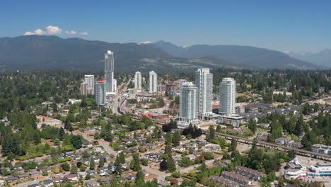 vista aérea del área alrededor de la estación burquitlam en coquitlam, columbia británica, canadá, con un paisaje montañoso en el fondo.