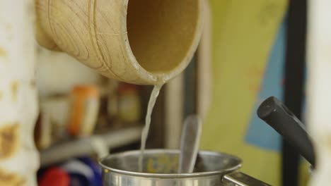 jugo de naranja y limón recién exprimido en cámara lenta entrando en una taza de aluminio para exprimir las frutas juntas para un delicioso batido