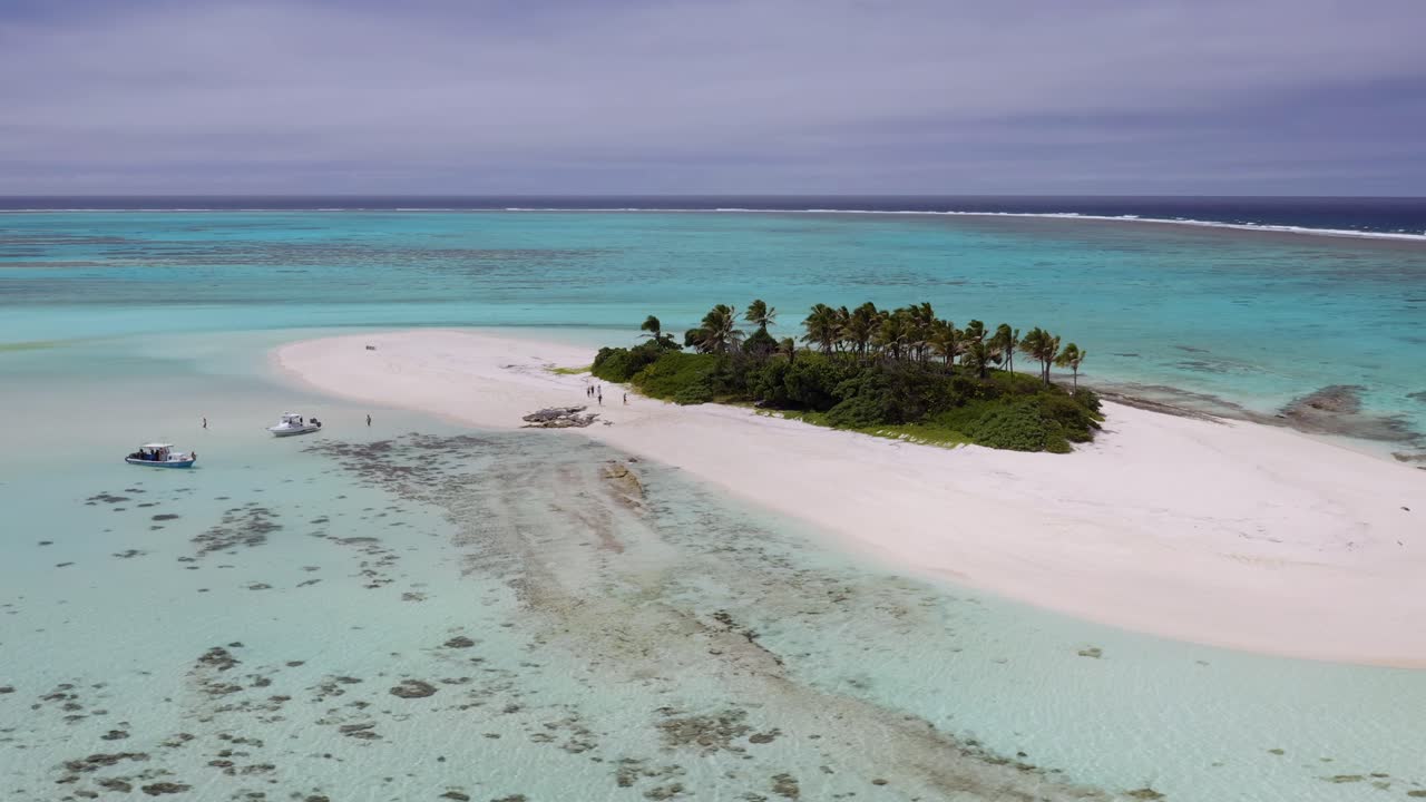 órbita en el sentido de las agujas del reloj alrededor de una pequeña isla de arena con palmeras y vegetación verde
