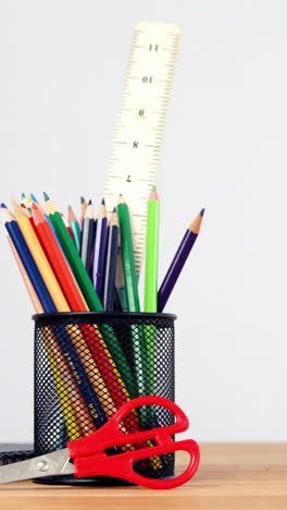 primer plano del soporte de la pluma con lápiz de color, diario y tijeras
