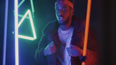 stylish black man performing in neon lights