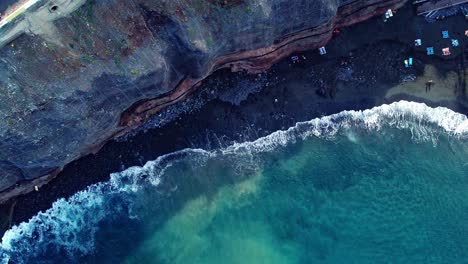 Fotografía-Cenital-De-Una-Onda-Larga-Que-Se-Desvanece-Suavemente-En-Una-Playa-Rocosa,-Tenerife,-España