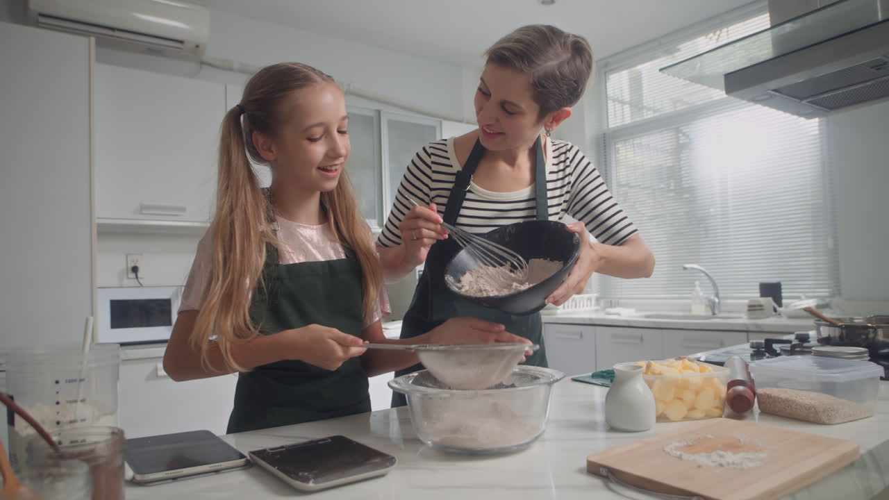 Mother Teaching Daughter to Make Dough at Kitchen