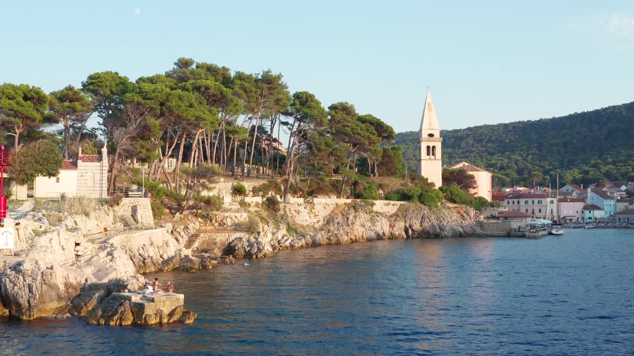Ripresa aerea bassa con carrello che entra in una baia a Veli Losinj, Croazia, in una giornata luminosa