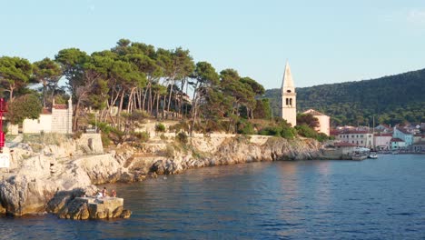 low aerial dolly shot entering a bay in veli losinj, croatia on a bright day