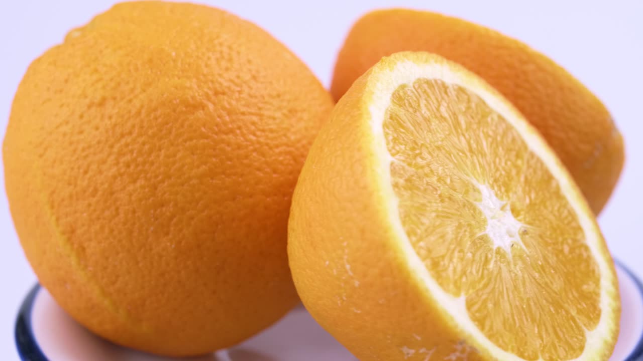 primer plano de naranja valencia fresca en rodajas con fondo blanco enfoque superficial y girando lentamente