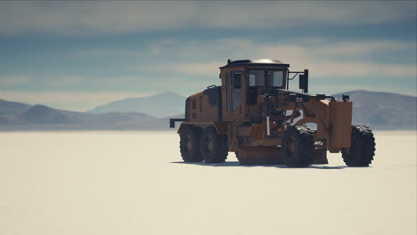 road grading machine on the salt desert road