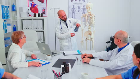 doctor explaining radiography in front of medical staff using skeleton