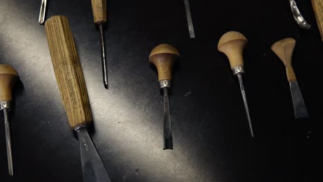 artisan méconnaissable sculptant un ornement en bois sur le backgammon. charpentier choisissant le bon outil - taille de planche et démarrage du travail. vue à haut angle