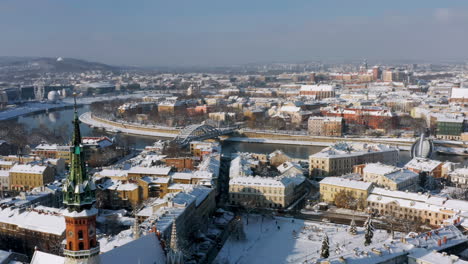 panorama of snow covered podgorze district with tenement houses (podgorski square with st. joseph's church) in krakow, poland