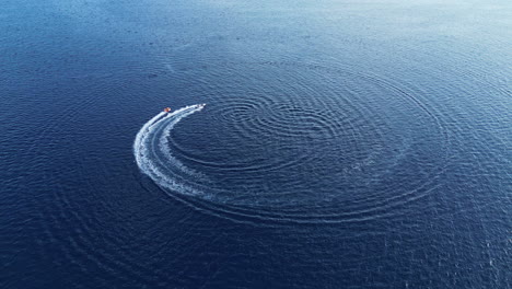 motorboat making circles on a deep blue water surface drone stady shoot. boat leaving the frame. croatia