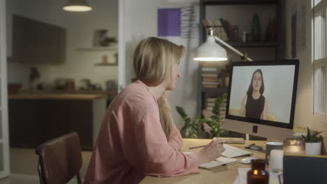 woman studying online with tutor in evening at home