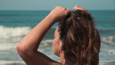 woman listening to music at the beach