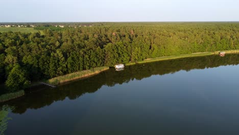 Pequeña-Casa-Flotante-Flotando-En-Un-Lago-Junto-A-Un-Bosque-En-Brandeburgo,-Alemania