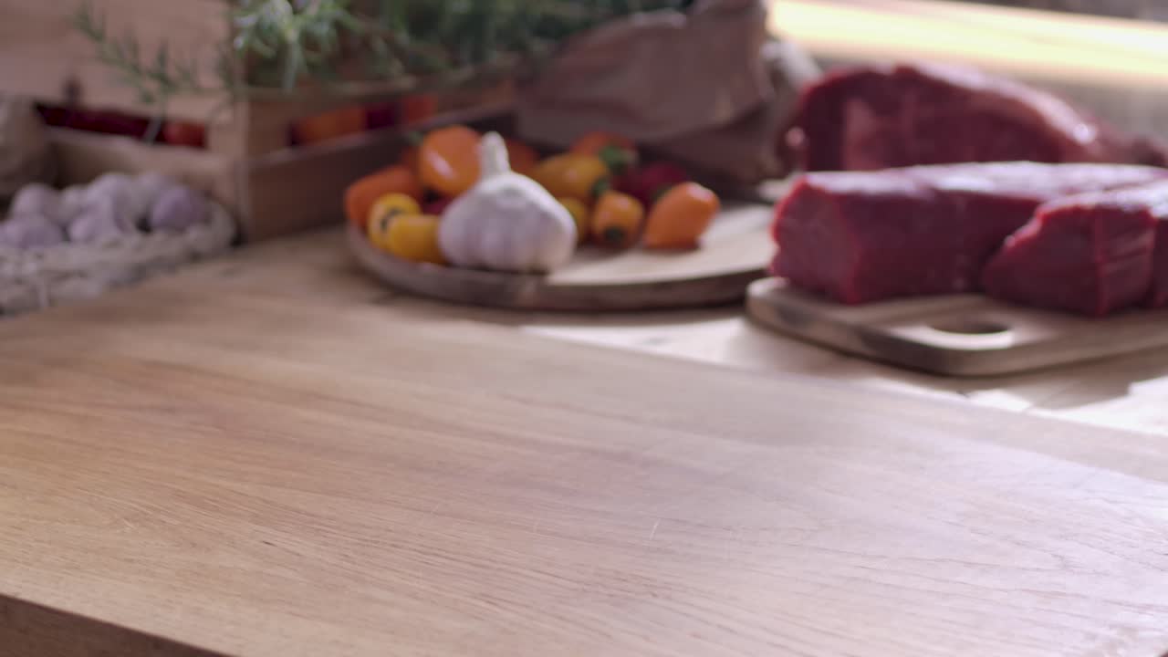 Primo piano di uno chef che appoggia un taglio fresco di manzo Wagyu Picanha altamente marmorizzato su un tagliere di legno in una cucina