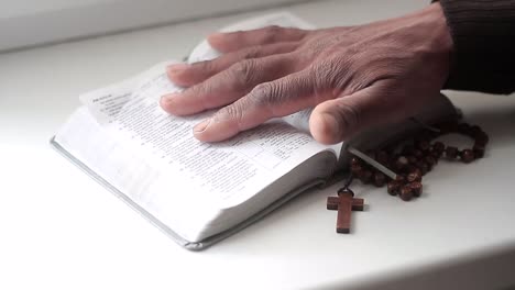 praying to god with hands together with bible and cross black man praying with black background stock video stock footage