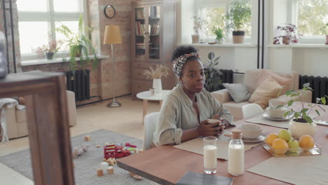 black woman enjoying breakfast in loft apartment