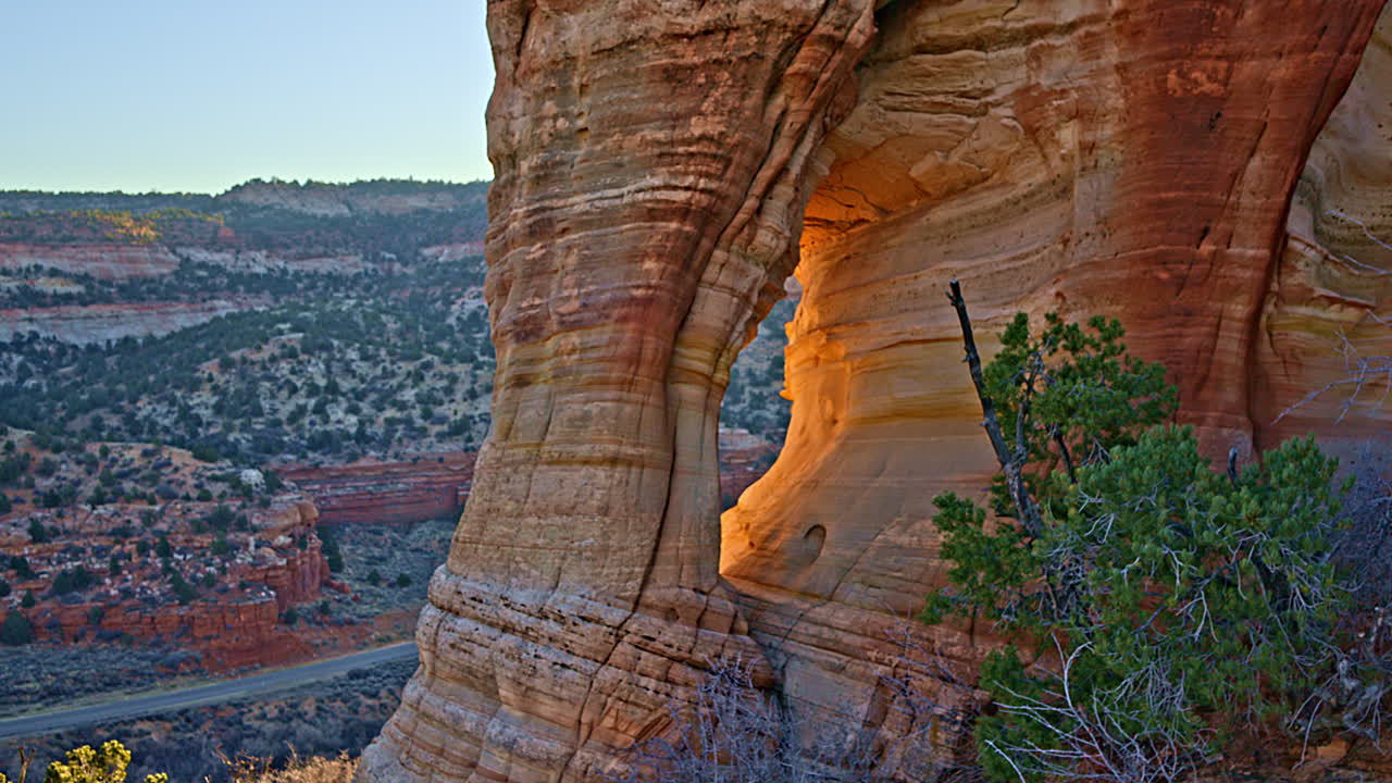Cinematic drone sweep capturing the beauty of a red rock arch under the soft morning light near Kanab.