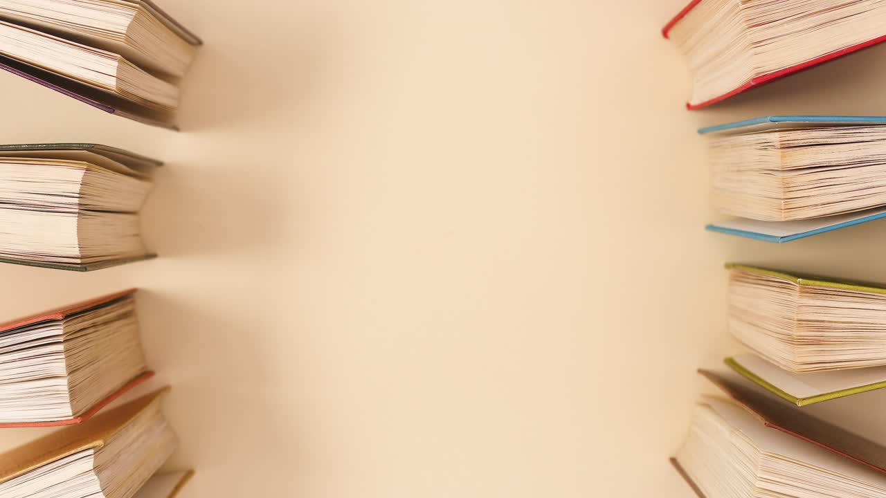 Hardcover vintage books open and close on beige background with copy space. Stop motion flat lay