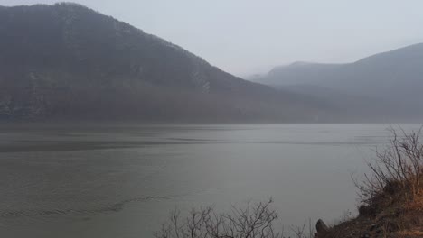 a beautiful, mysterious foggy and rainy day during autumn on the hudson river in new york, with the appalachian mountains in the background