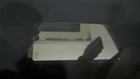 car side window being tinted using foil. removing air bubbles
