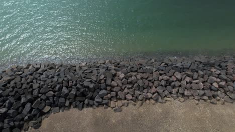 Drone-Ascendiendo-Sobre-Rocas-De-Defensas-Marinas-En-Elmer-Beach-Cerca-De-Middleton-On-Sea,-Bognor-Regis,-West-Sussex,-Reino-Unido