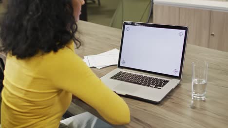 Video-of-biracial-woman-using-laptop-with-copy-space-on-screen