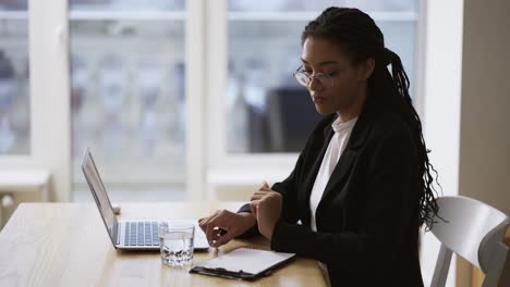 afro american girl secretary business woman sitting at table at office using laptop